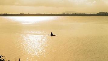 Silhouette of old man floating in a small boat video