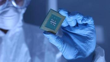 L'homme en salle blanche tient la micropuce cpu de l'ordinateur video