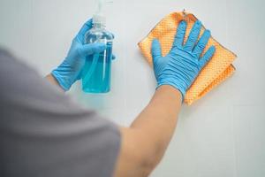 Cleaning tile wall with cloth and alcohol in kitchen at home for protect covid 19 coronavirus