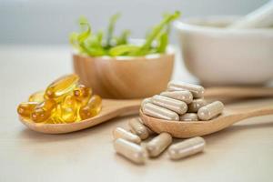 medicina alternativa cápsula orgánica a base de hierbas con vitamina e omega 3 aceite de pescado medicamento mineral con hojas de hierbas suplementos naturales para una vida sana y buena foto