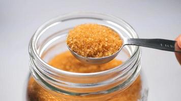 Closeup macro photography of a bowl full of caramelized brown colored sugar and a spoon full of it photo