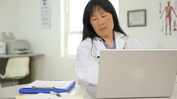 femme médecin examine un ordinateur portable
