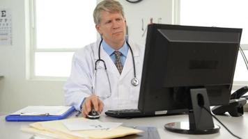 Doctor at desk working on computer video