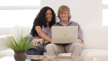 Couple sitting on couch with laptop computer video