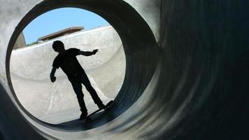Skateboarder rides a full pipe, slow motion video
