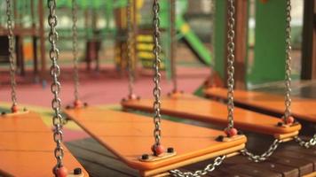 Orange hanging bridge on the chains swinging on the playground video