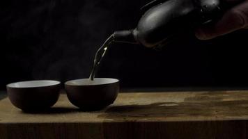 Teezeremonie und eine schwarze Teekanne gießen Tee video