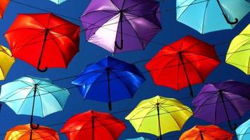 Vivid colorful umbrellas sweep overhead video