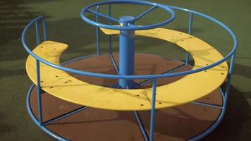 Yellow carousel rotates on the playground