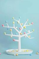Pequeño árbol decorativo con coloridos huevos de codorniz en las ramas de fondo de Pascua con espacio de copia