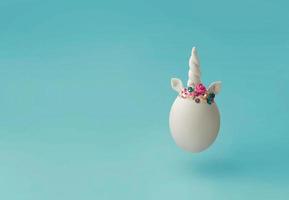 Single white egg with unicorn horn Creative minimal Easter background with copy space photo