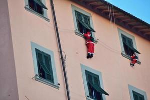 Red and black hanging decor on beige concrete building photo