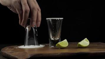 The bartender prepares tequila and dabs a stick in the salt video