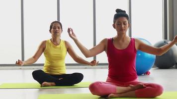 Dos mujeres haciendo ejercicios de yoga definiendo su respiración.