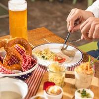 Man cutting tasty German sausage with beer photo