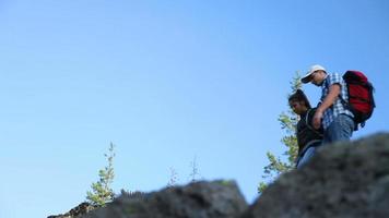 Backpackers climb to top of rock video