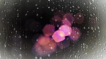 Luz colorida bokeh con vista de gota de lluvia desde la ventana del automóvil 4k animación gotas de lluvia en la ventana del automóvil con semáforos borrosos en el fondo video