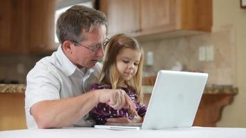 Grandfather and granddaughter on laptop