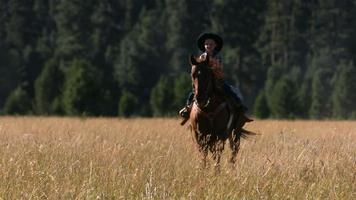 Young cowboy riding horse, slow motion video