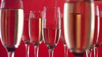 Gießen Champagner auf rotem Hintergrund, Zeitlupe video