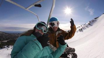 dois snowboarders subindo pelo teleférico video