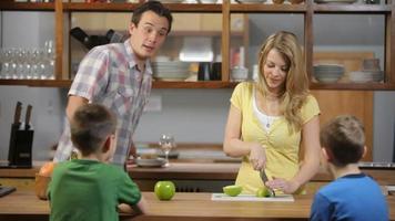 Mother and Father in kitchen prepare snack for kids video
