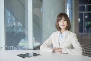 Attractive asian business woman smiling in workplace photo