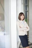 Atractiva mujer de negocios asiática sonriendo fuera de la oficina foto