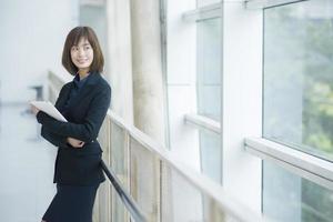 Atractiva mujer de negocios asiática trabajando en tablet PC fuera de la oficina foto
