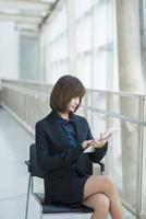 Attractive asian business woman working on tablet computer outside Office photo