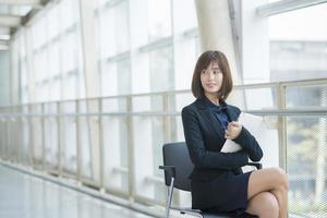 Attractive asian business woman working on tablet computer outside Office photo