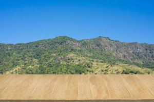 Wood floor with background of mountain view and blue sky photo