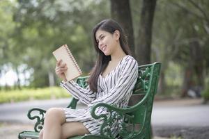 Attractive woman reading a book in the park