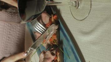 vídeo vertical linda mulher loira comendo e bebendo na hora do almoço em restaurante video