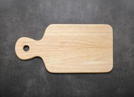 Empty vintage wooden cutting board set up on concrete background with copy space photo