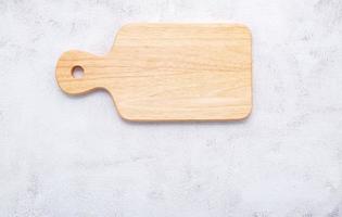 Empty vintage wooden cutting board set up on concrete background with copy space photo