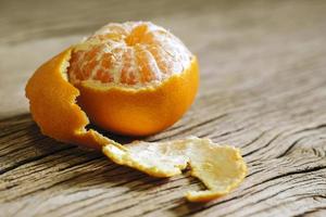 Mandarin orange peeled half on wood background