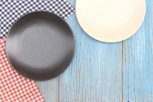 Black and white plate on tablecloth on wood table background photo