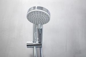 Cabezal de ducha en una pared de microcemento gris de un baño moderno