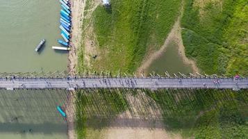 Vista aérea superior del puente de madera con barco turístico en Tailandia foto