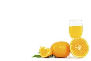 Freshly squeezed orange juice in a glass decorated with citrus fruits and orange leaves on white background with copy space photo