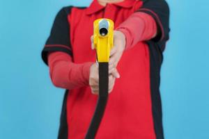 Woman hold fuel nozzle on blue background photo