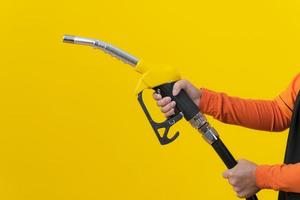 Woman hold fuel nozzle on yellow background photo