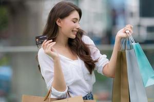 Retrato al aire libre de mujer feliz sosteniendo bolsas de la compra y cara sonriente foto