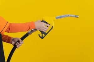 Woman hold fuel nozzle on yellow background photo