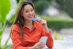 retrato al aire libre de mujer feliz con tarjeta de crédito foto