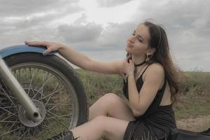 brunette biker on a motorcycle in lavender field against the sky with clouds slow motion photo