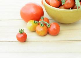 Macro cerca de tomates cherry frescos, vegetales sobre fondo de mesa de madera foto