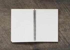 Notepad blank page on wooden background photo