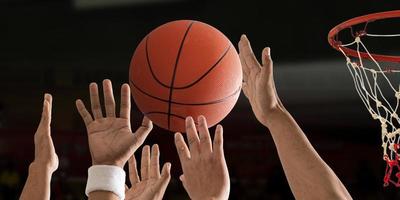 Basketball ball is flying with basketball hoop over a basketball court photo